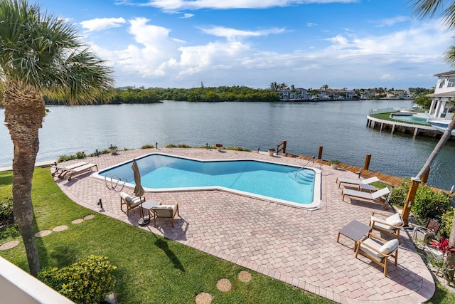 view of swimming pool featuring a lawn, a water view, a patio area, and a fenced in pool