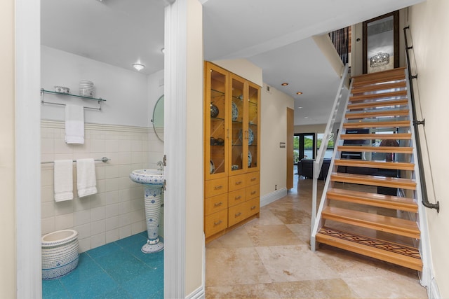 stairs with tile patterned floors and tile walls