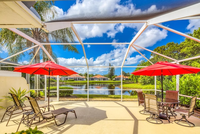 view of patio / terrace with a water view and glass enclosure