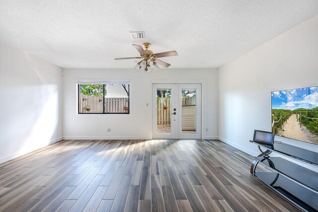 5606 Channel Dr, Lake Worth, FL 33463 - unfurnished living room featuring a textured ceiling, visible vents, ceiling fan, baseboards, and wood finished floors