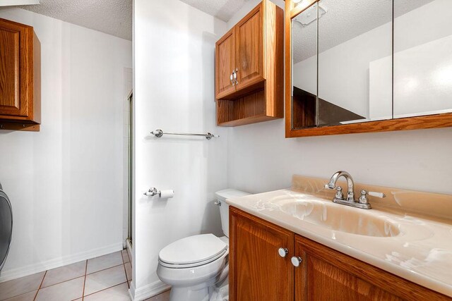 5606 Channel Dr, Lake Worth, FL 33463 - full bath with vanity, tile patterned floors, toilet, a shower with shower door, and a textured ceiling