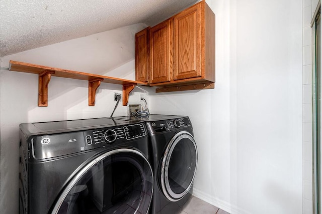 5606 Channel Dr, Lake Worth, FL 33463 - laundry area featuring light tile patterned floors, cabinet space, a textured ceiling, and independent washer and dryer