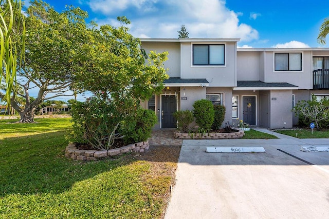 5606 Channel Dr, Lake Worth, FL 33463 - multi unit property featuring a shingled roof, a front lawn, uncovered parking, and stucco siding