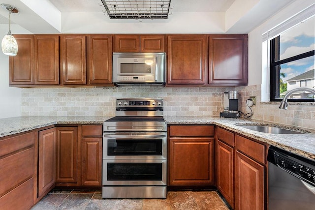 5606 Channel Dr, Lake Worth, FL 33463 - kitchen with light stone counters, tasteful backsplash, brown cabinets, a sink, and stainless steel appliances