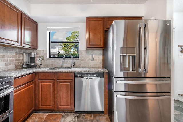 5606 Channel Dr, Lake Worth, FL 33463 - kitchen with light stone counters, appliances with stainless steel finishes, decorative backsplash, and a sink