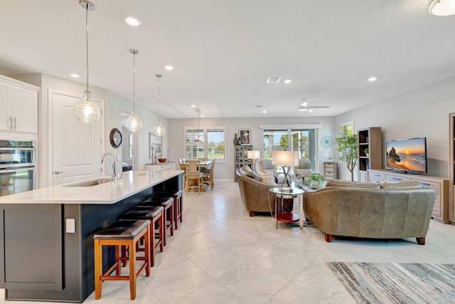 living room featuring recessed lighting, ceiling fan, light tile patterned floors, and visible vents