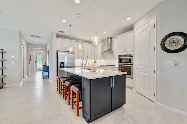 13339 SW Gingerline Dr, Port Saint Lucie, FL 34987 - kitchen featuring wall chimney exhaust hood, appliances with stainless steel finishes, a sink, tasteful backsplash, and white cabinets