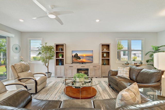living area with recessed lighting, a ceiling fan, and baseboards