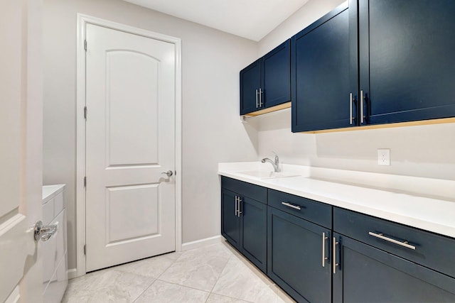washroom with baseboards, a sink, and marble finish floor