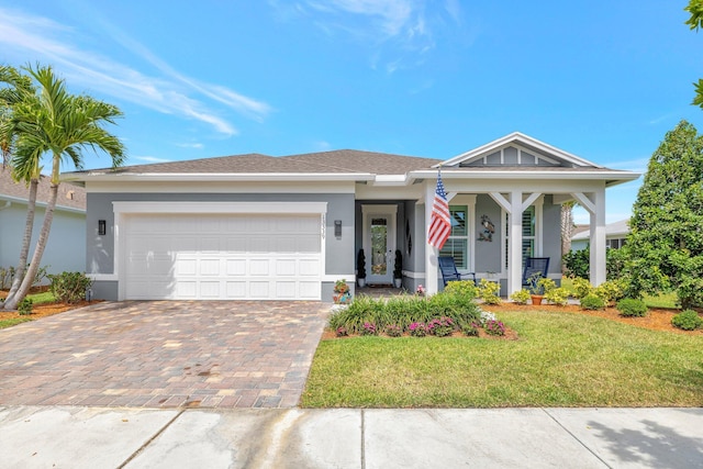 view of front facade featuring a garage, a front lawn, stucco siding, and driveway