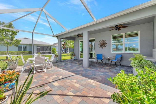 view of patio featuring a lanai, ceiling fan, and outdoor dining space