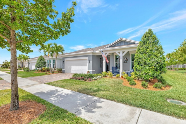 view of front of house with a front lawn, covered porch, stucco siding, an attached garage, and driveway