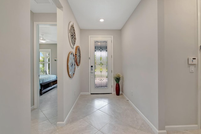 entryway with light tile patterned floors, baseboards, and a ceiling fan