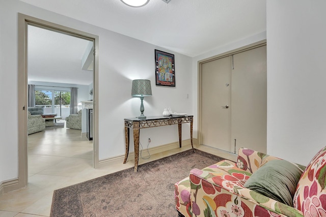 3212 NE 12th St Unit 201, Pompano Beach, FL 33062 - living area with a fireplace, tile patterned flooring, and baseboards