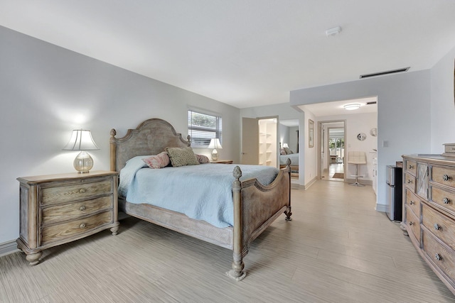 3212 NE 12th St Unit 201, Pompano Beach, FL 33062 - bedroom with baseboards, visible vents, light wood finished floors, and ensuite bathroom