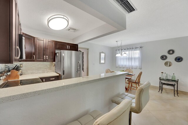 3212 NE 12th St Unit 201, Pompano Beach, FL 33062 - kitchen with dark brown cabinetry, visible vents, backsplash, light stone counters, and appliances with stainless steel finishes