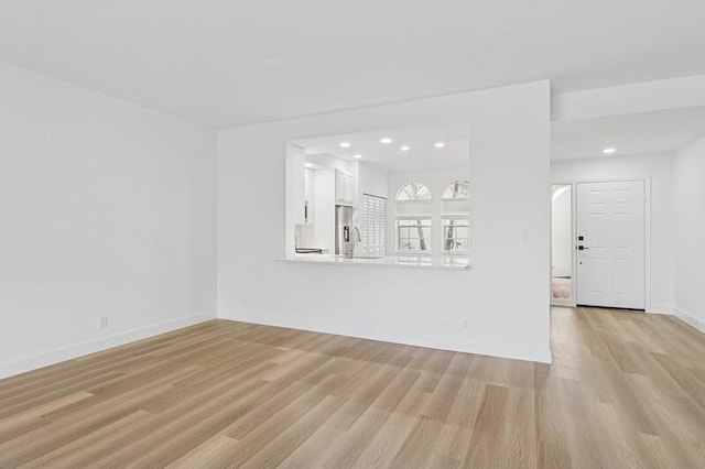 unfurnished living room featuring light wood-style flooring, recessed lighting, and baseboards