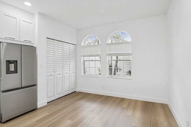 unfurnished dining area featuring light wood-style floors, baseboards, and recessed lighting