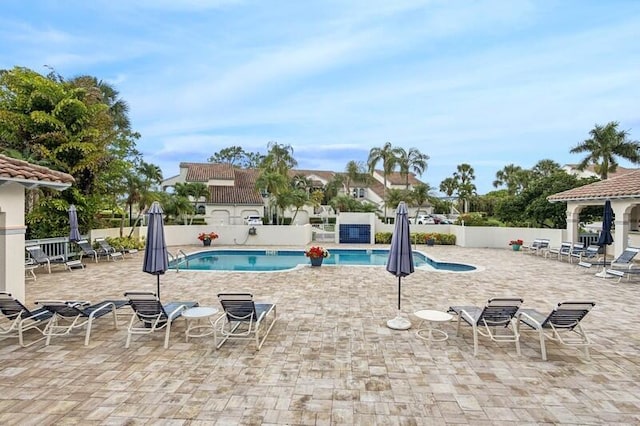 community pool with fence and a patio