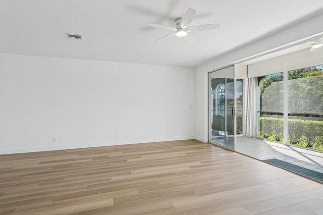 spare room featuring ceiling fan, wood finished floors, and baseboards