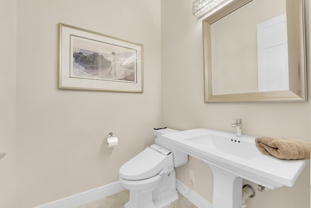 bathroom with baseboards and toilet