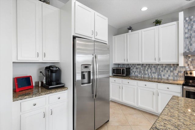 kitchen featuring appliances with stainless steel finishes, white cabinetry, tasteful backsplash, and recessed lighting