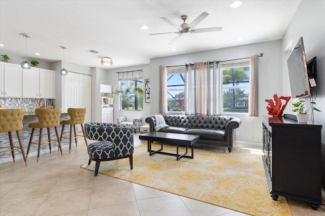 living area featuring plenty of natural light, a ceiling fan, recessed lighting, and light tile patterned floors