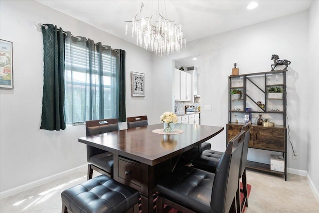 dining space featuring a chandelier and baseboards