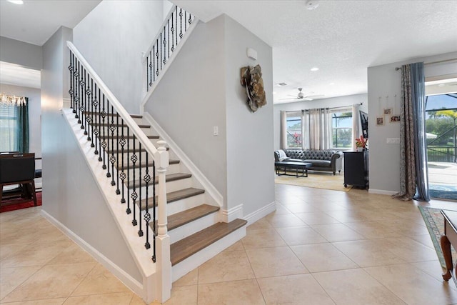 stairway featuring tile patterned flooring, baseboards, ceiling fan, a textured ceiling, and recessed lighting