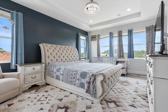 11400 SW Reston Ct, Port Saint Lucie, FL 34987 - bedroom featuring light wood-type flooring, a chandelier, recessed lighting, and a tray ceiling