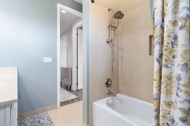 full bath with baseboards, tile patterned flooring, shower / bath combination with curtain, and vanity