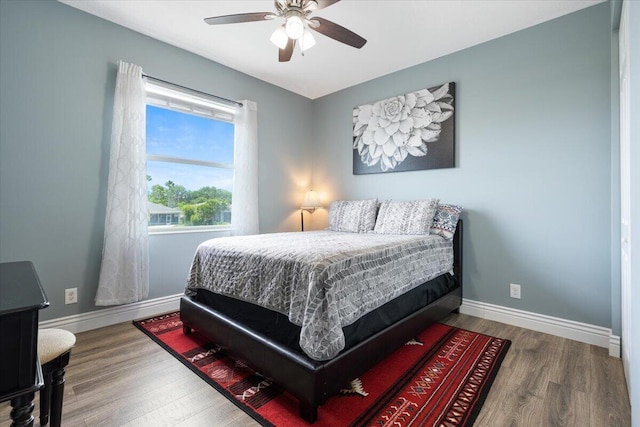 bedroom featuring wood finished floors, baseboards, and ceiling fan