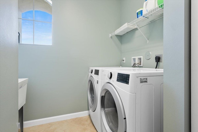 washroom with washer and dryer, baseboards, and light tile patterned floors