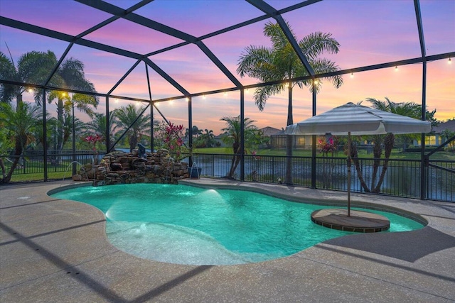 pool at dusk featuring a patio area, a fenced backyard, and a lanai