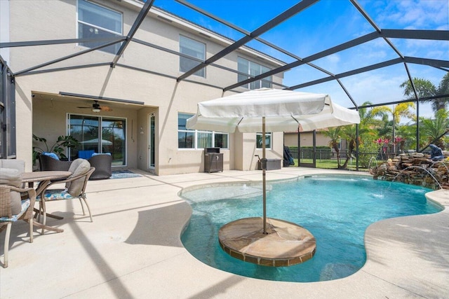 view of pool with a patio, ceiling fan, and glass enclosure