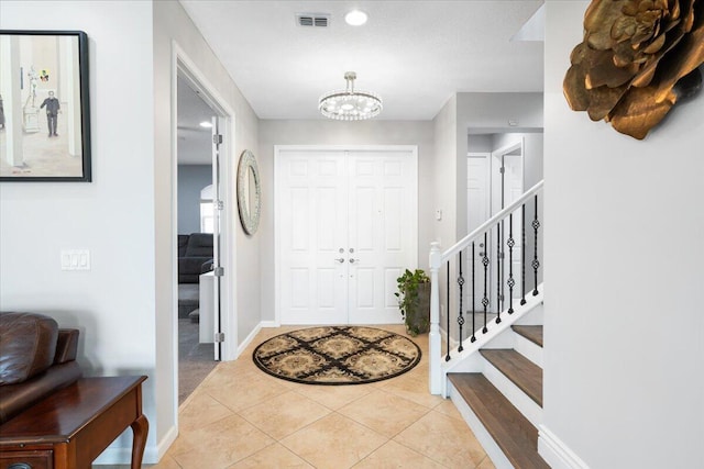 foyer entrance featuring a chandelier, baseboards, stairway, light tile patterned flooring, and recessed lighting