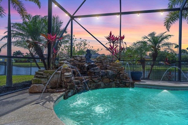 pool at dusk featuring fence