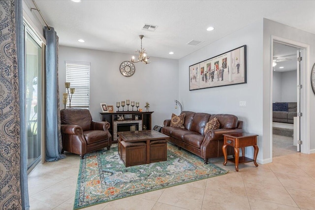 living room featuring a chandelier, light tile patterned floors, recessed lighting, and baseboards