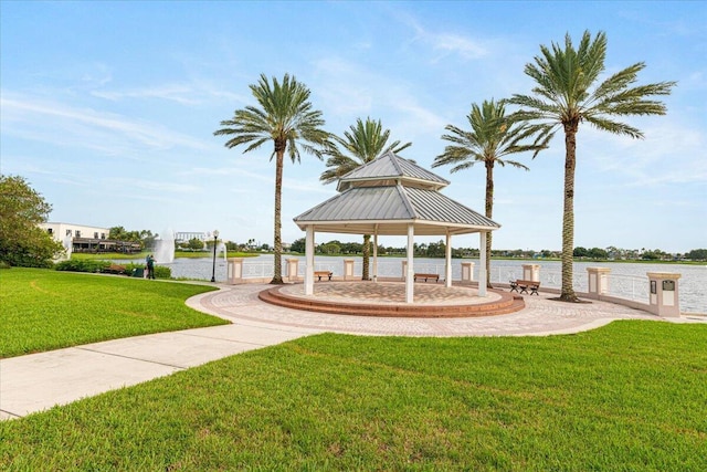 surrounding community with a gazebo, a lawn, and a water view
