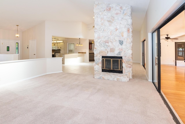3984 SE Fairway E, Stuart, FL 34997 - unfurnished living room featuring baseboards, a ceiling fan, carpet flooring, and a fireplace