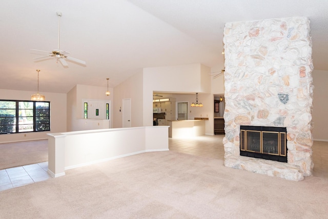 3984 SE Fairway E, Stuart, FL 34997 - unfurnished living room featuring carpet flooring, a fireplace, tile patterned floors, high vaulted ceiling, and ceiling fan with notable chandelier
