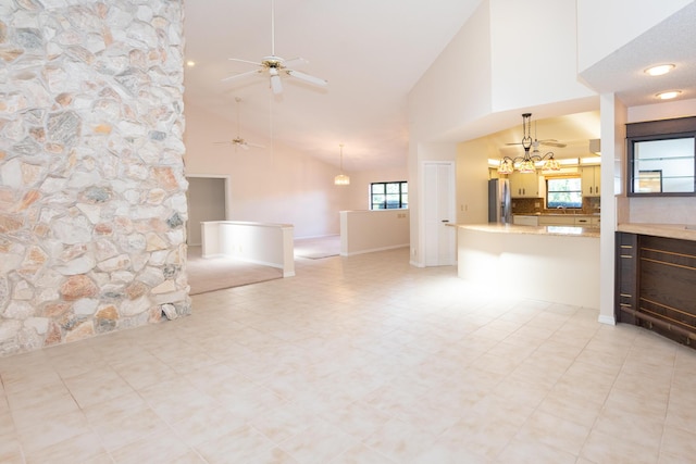 3984 SE Fairway E, Stuart, FL 34997 - unfurnished living room featuring high vaulted ceiling, plenty of natural light, and ceiling fan with notable chandelier