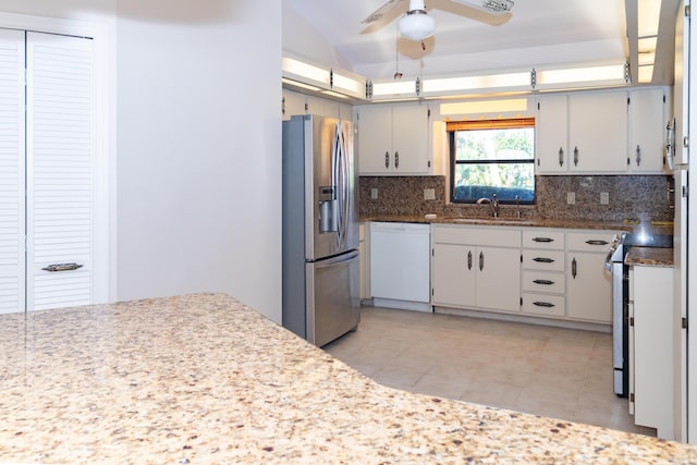 3984 SE Fairway E, Stuart, FL 34997 - kitchen featuring light tile patterned flooring, appliances with stainless steel finishes, a sink, a ceiling fan, and backsplash