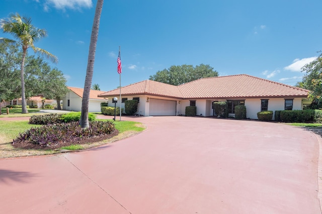 3984 SE Fairway E, Stuart, FL 34997 - view of front facade with curved driveway, a garage, stucco siding, and a tiled roof