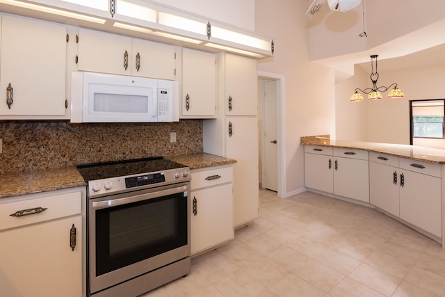 3984 SE Fairway E, Stuart, FL 34997 - kitchen featuring electric range, white cabinetry, decorative light fixtures, white microwave, and backsplash
