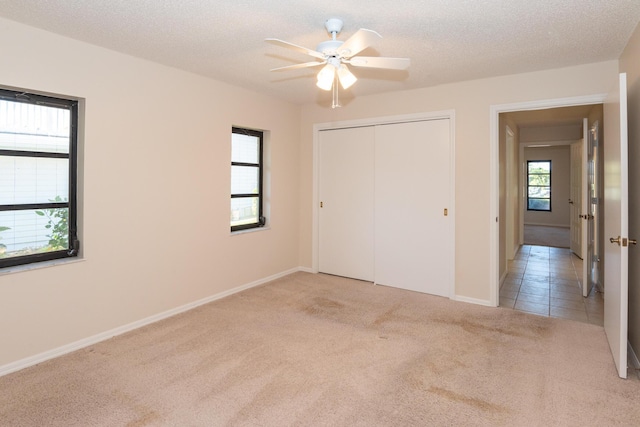 3984 SE Fairway E, Stuart, FL 34997 - unfurnished bedroom with a closet, carpet, ceiling fan, and baseboards