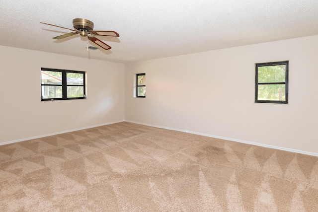 3984 SE Fairway E, Stuart, FL 34997 - unfurnished room featuring a healthy amount of sunlight, baseboards, a ceiling fan, and light colored carpet