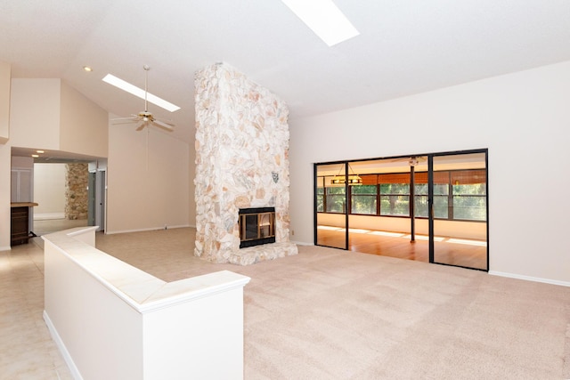 3984 SE Fairway E, Stuart, FL 34997 - unfurnished living room featuring light colored carpet, a fireplace, a skylight, and high vaulted ceiling