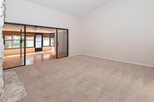 3984 SE Fairway E, Stuart, FL 34997 - carpeted empty room featuring baseboards and vaulted ceiling