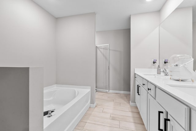 885 SW Squirrel Ave, Port Saint Lucie, FL 34953 - bathroom with a bath, a shower stall, double vanity, baseboards, and wood finish floors